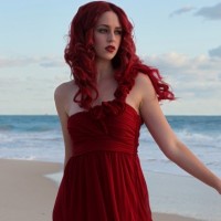 Фото с эффектной девушкой с красными волосами в платье на пляже